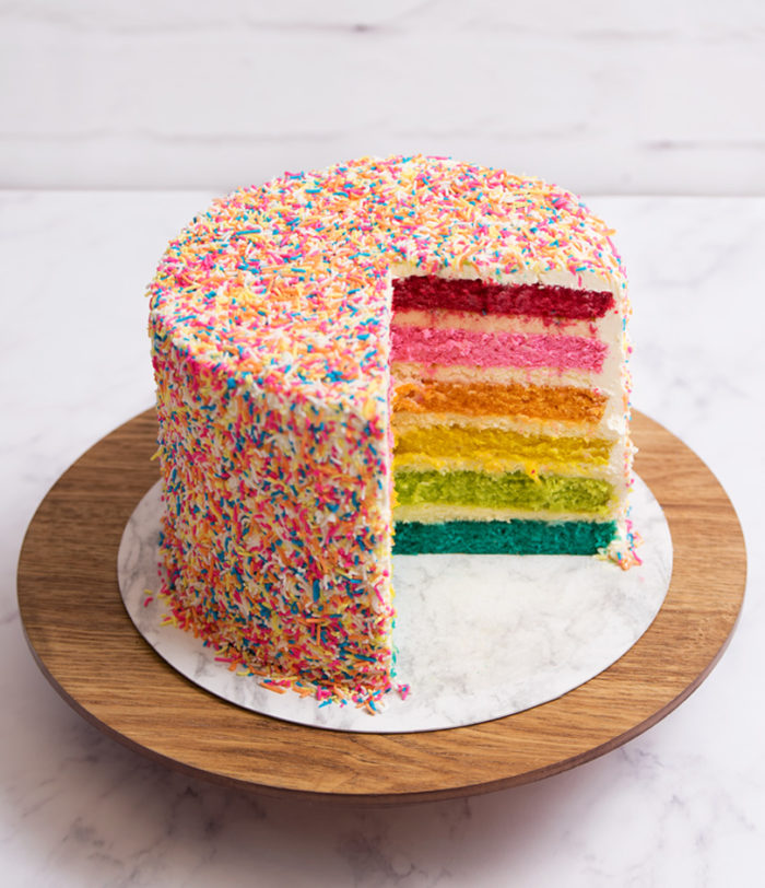 Vibrant and playful, this 6-layer rainbow cake is a treat for the eyes. Covered in multicolored sprinkles, it's a delightful indulgence for the senses.